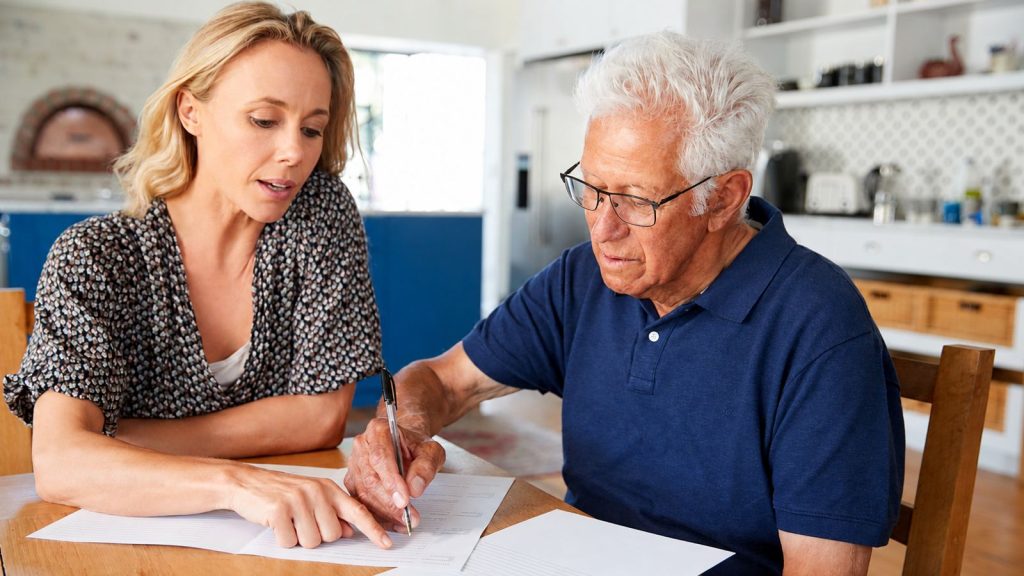 Elderly man and daughter filling out paperwork