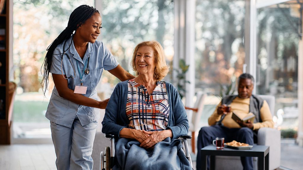 Senior in wheel chair with caregiver