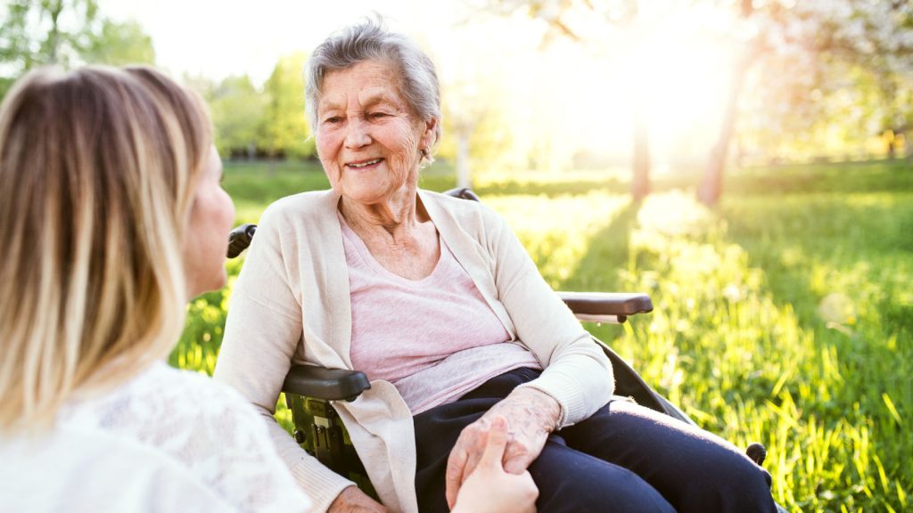 Caregiver with disabled woman in a park