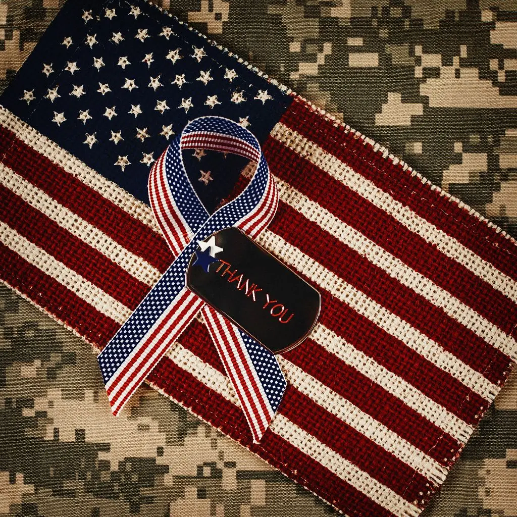 Remembrance ribbon and American flag honoring veterans and surviving spouses